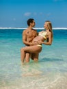 Young pregnant woman with husband at paradise beach. Happy couple at tropical island