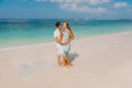 Young pregnant woman with husband relaxing at paradise beach. Happy couple in tropics Royalty Free Stock Photo