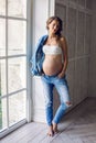 Young pregnant woman in jeans clothes in Studio