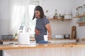 A young pregnant woman is in the kitchen in her house. A woman drinks tea and looks at her laptop while reading the news Royalty Free Stock Photo