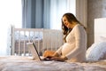 Young pregnant woman with laptop in the bed Royalty Free Stock Photo