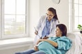 Young pregnant woman lying on the couch visiting gynecologist doctor in hospital or medical clinic. Royalty Free Stock Photo