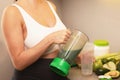 Pregnant woman make a green protein cocktail at home