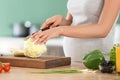 Young pregnant woman making fresh vegetable salad in kitchen, closeup Royalty Free Stock Photo