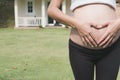 young pregnant woman making heart shape sign on her tummy in fro Royalty Free Stock Photo