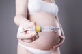 Young pregnant woman making injection in the stomach. Close-up studio shot