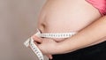 Young pregnant woman measures her belly with measurement band Royalty Free Stock Photo