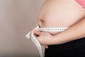 Young pregnant woman measures her belly with measurement band Royalty Free Stock Photo