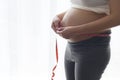 Young pregnant woman measuring belly centimeter, healthcare and pregnancy care Royalty Free Stock Photo