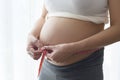 Young pregnant woman measuring belly centimeter, healthcare and pregnancy care Royalty Free Stock Photo