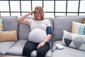 Young pregnant woman measuring pulse using tensiometer at home