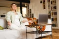 Young pregnant woman meditating and using laptop while sitting on couch Royalty Free Stock Photo