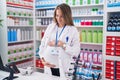 Young pregnant woman pharmacist smiling confident touching belly at pharmacy