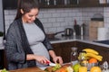 Young pregnant woman preparing healthy food with fruit and vegetables Royalty Free Stock Photo