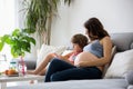 Young pregnant woman, reading a book at home to her boy Royalty Free Stock Photo