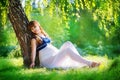 Young pregnant woman relaxing in park outdoors, healthy pregnancy. Happy pregnant woman on nature. Beautiful pregnant woman Royalty Free Stock Photo