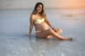 Young pregnant woman relaxing on sandy beach in summer day. Royalty Free Stock Photo