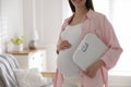 Young pregnant woman with scales at home