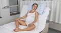 Young pregnant woman sitting upright on delivery bed