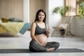 Young Pregnant Woman Sitting On Yoga Mat And Holding Glass With Water Royalty Free Stock Photo