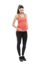 A young pregnant woman in sportswear stands in full growth. Isolated on white background. Vertical Royalty Free Stock Photo