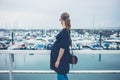 Pregnant woman in harbor looking at boats