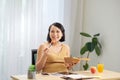 A young pregnant woman standing in home office and using tablet pc. Breakfast time Royalty Free Stock Photo