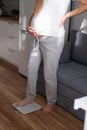 Young pregnant woman standing on the scale at home Royalty Free Stock Photo