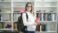 Young pregnant woman student smiling confident holding books at library university Royalty Free Stock Photo