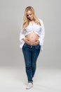 Young pregnant woman in studio. Beautiful stomach. Pregnancy, childbearding and new life concept. Royalty Free Stock Photo