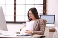 Young pregnant woman suffering from pain while working Royalty Free Stock Photo