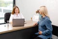 Young pregnant woman visiting her gynecologist in modern clinic. Woman sitting on chair and talking to her doctor Royalty Free Stock Photo