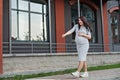 A young pregnant woman walking dancing along the city windows Royalty Free Stock Photo