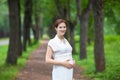 Young pregnant woman walking in a park