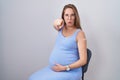 Young pregnant woman wearing band aid for vaccine injection pointing with finger to the camera and to you, confident gesture Royalty Free Stock Photo