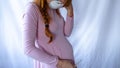 A young pregnant woman is wearing a mask and staying sick at home