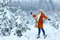 Young pregnant woman wearing warm clothes having fun on winter forest Royalty Free Stock Photo