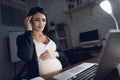 Young pregnant woman work at home alone. Pregnant woman experiences headache. Royalty Free Stock Photo