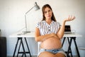 Pregnant woman working from home. Career and pregnancy concept