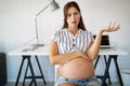 Pregnant woman working from home. Career and pregnancy concept