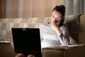 Young pregnant woman working on a laptop at home on the couch. Remote work Royalty Free Stock Photo