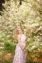 Young pregnant womani n floral pink dress standing the flowering trees Royalty Free Stock Photo