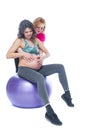 Young pregnant woman exercising with physiotherapist in birthing school. Doctor`s help conceptat in antenatal class Royalty Free Stock Photo