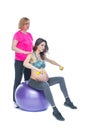 Young pregnant woman exercising with physiotherapist in birthing school. Doctor`s help conceptat in antenatal class Royalty Free Stock Photo