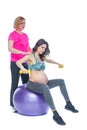 Young pregnant woman exercising with physiotherapist in birthing school. Doctor`s help conceptat in antenatal class Royalty Free Stock Photo