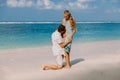 Young pregnant woman with husband relaxing at paradise beach. Happy couple in tropics Royalty Free Stock Photo