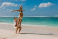 Young pregnant woman with husband relaxing at paradise beach. Happy couple in tropics Royalty Free Stock Photo