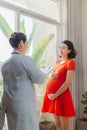 Young pregnant woman listening to prescription of doctor after regular examination at hospital