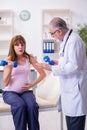 Young pregnant woman visiting old male doctor gynecologist Royalty Free Stock Photo