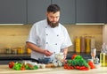 Young prepares a poke bowl in a modern kitchen. The man prepares food at home. Cooking healthy and tasty food